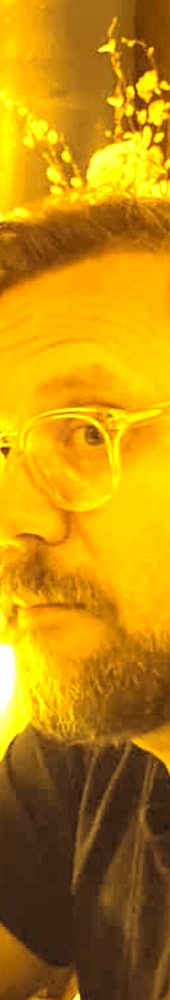 Yellow toned shot of Jason smiling while outside